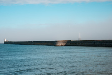 Lighthouse hiding in a haze in Aberdeen Harbour entrance © anastasstyles