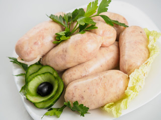 Raw sausages with greens on the plate