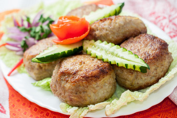 Beef cutlets with greens and vegetables on the plate