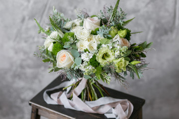 Spring bouquet of mixed flowers on vintage gray wall background behind