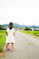 田んぼ道を散歩する姉弟　Sister brother walking in rice field