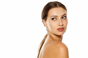 Fototapeta premium A sensual portrait of a young woman with a ponytail and bare shoulders