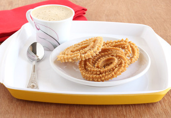 Homemade Indian snack chakli, also known as murrukku, a traditional and popular food, and coffee.