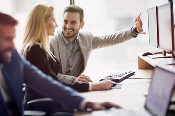Portrait of cheerful business couple working on computer