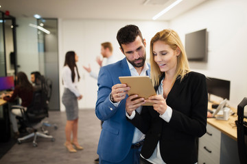 Portrait of attractive business partners using tablet