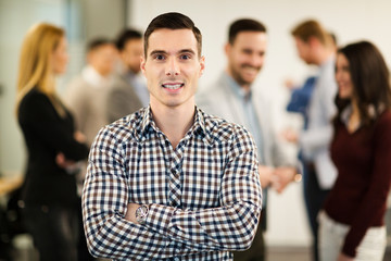 Fototapeta premium Portrait of handsome young businessman with his colleagues