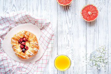 Breakfast concept with flowers on wooden background top view