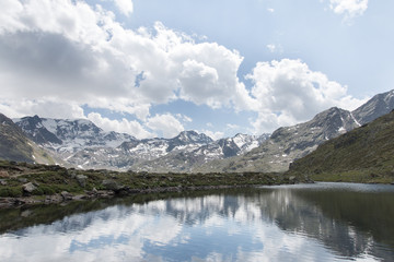 Fototapeta na wymiar View at the mountains with mountain lake and reflection