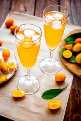 cocktail with kumquat on wooden background