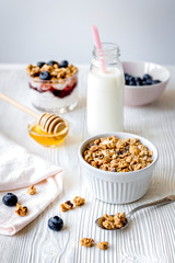 Cooking breakfast with granola and berries on white kitchen back