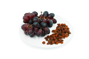 A bunch of grapes and raisins on a plate