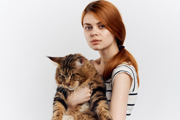 Beautiful woman on a white background holds a cat, portrait, pets