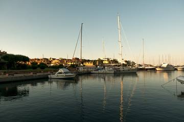Fototapeta na wymiar Luxury Yachts moored in a harbor of Porto Cervo on the early sunset, Sardinia, Italy