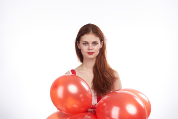 Beautiful woman on white isolated background holds red balloons, holiday, blank space for copy