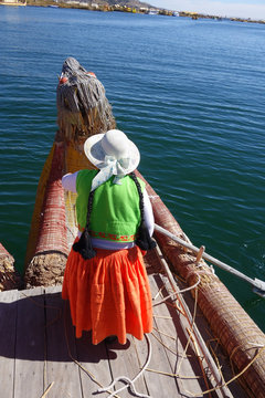 Frau rudert auf traditionellem Boot in Peru auf dem Titicacasee