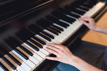 Fototapeta premium Girl playing on black piano