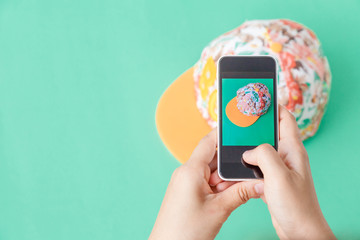young women taking photo to hat with cell telephone or smartphone digital camera for Post to sell Online on the Internet . Customise pastel bright colors tone .