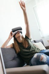 Beautiful young woman enjoying virtual reality at her home.
