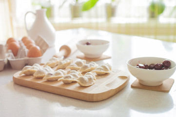 Fototapeta na wymiar Raw dumplings with cherry, preparation for cooking