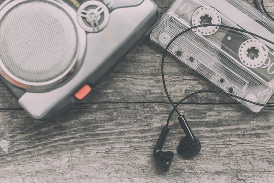 Vintage walkman cassette player with earbuds and tape cassette, retro style toned image