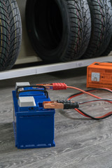 Recharging the car battery on a wooden background