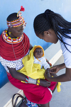 Nurse examing Mother and Baby in clinic. Kenya, Africa.