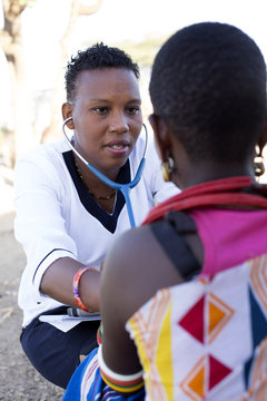 Nurse examing female patient in rural village. Kenya, Africa