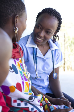 Nurse examing Mother and Daughter in clinc. Kenya, Africa.