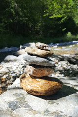 Fototapeta na wymiar Balance Stone pyramid on the shore of a mountain river