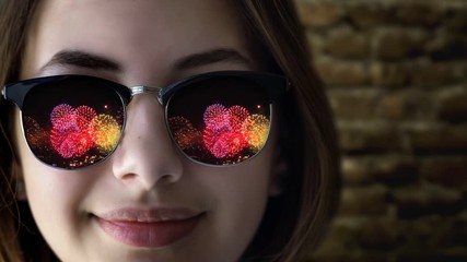 Cinemagraph - Firework reflected in young beautiful girl's sunglasses. Concept of celebrate. Motion Photo.