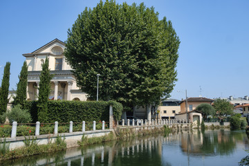 Obraz premium Gorgonzola (Milan): canal of Martesana and church