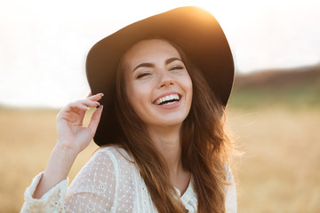 Obraz premium Beautiful young happy woman standing in the field