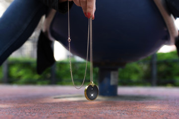 Girl hanging chakra medallion maded of many minerals, pieces of meteorite with golden frame.