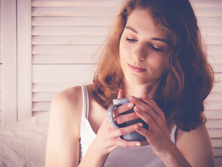 Beautiful woman drinking a coffee in her bed. Lifestyle concept.