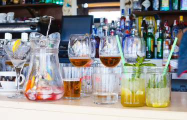 Drinks and empty glasses on bar