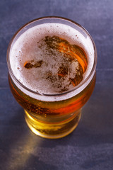 Glass of beer on gray background. Ale. View from above, top shot