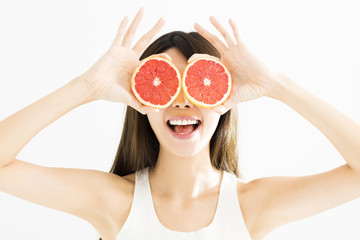 happy Woman covering her eye with grapefruit