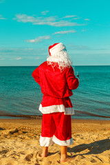 Obraz premium Santa Claus is standing on the beach.