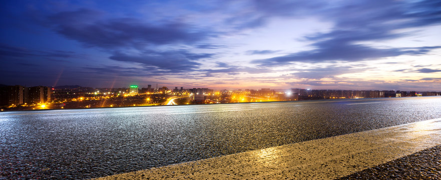 empty road and cityscape of modern city at twilight