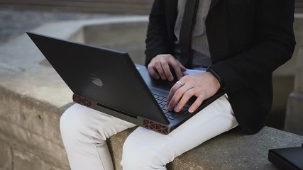 A young man in his glasses holds documents in his hand