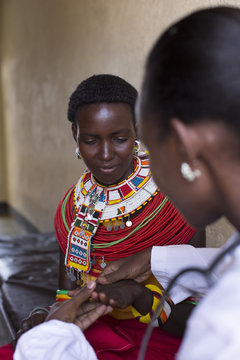 Female Doctor examining female Samburu patient. Kenya, Africa.