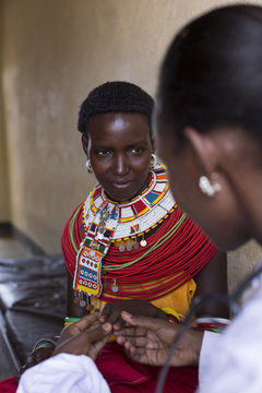 Female Doctor examing female Samburu patient. Kenya, Africa.