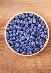 Blueberries in clay bowl. Freshly picked berries on rustic background. Blueberry antioxidant superfood, concept for healthy eating. View from above, top studio shot