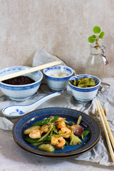 Stir fry with shrimps. Oriental food. Blue plate, chineese bowls.