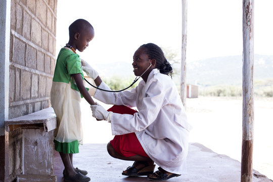 Female doctor examing child (female). Kenya, Africa.