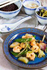 Stir fry with shrimps. Oriental food. Blue plate, chineese bowls.