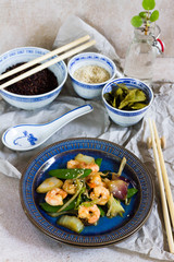 Stir fry with shrimps. Oriental food. Blue plate, chineese bowls.