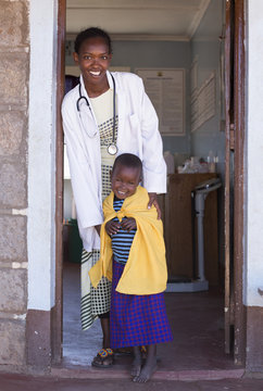 Doctor with young Maasai child, at clinic. Kenya, Africa.
