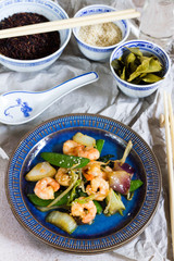 Stir fry with shrimps. Oriental food. Blue plate, chineese bowls.