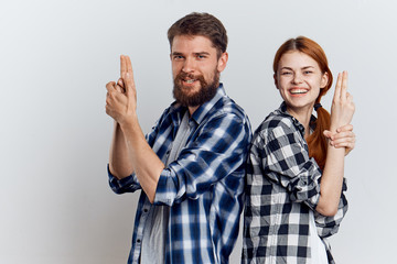 Young woman with long hair and a man with a beard on a light background, fun, laughing, friendship, relationship